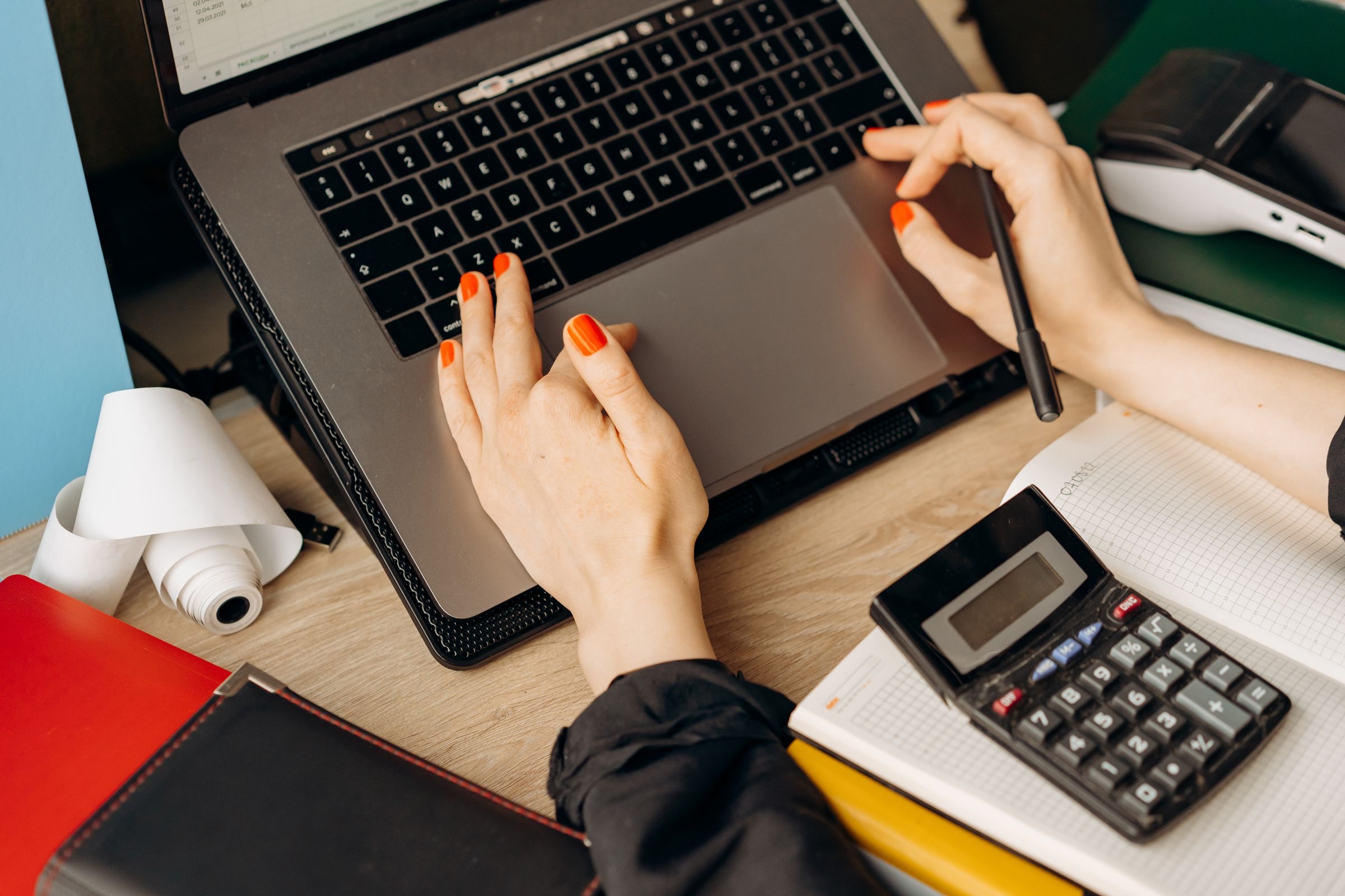 A company owner and a bookkeeper reviewing a BV's ledger on a laptop before the annual accounts are drawn up.