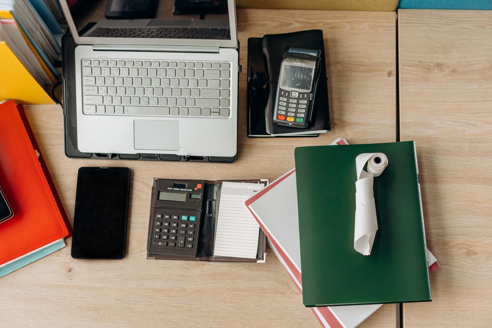 Invoices, bank statements and a binder on a desk next to a laptop, the records a Dutch BV hands over for its books.