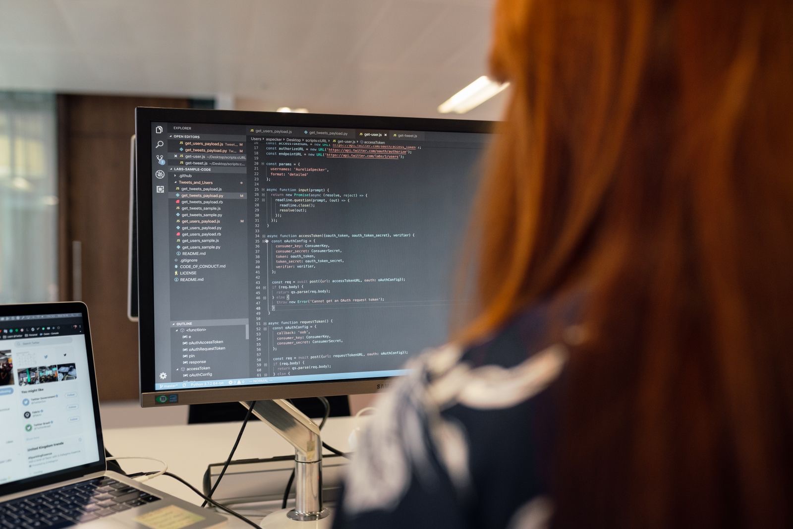 A software developer working on code at a monitor in an office