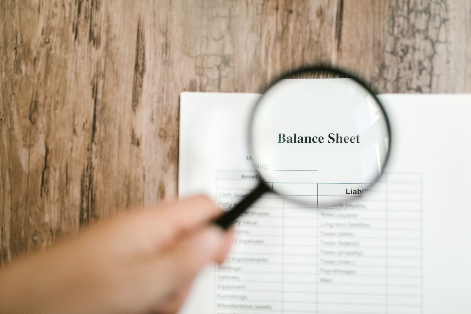 Two people reviewing a printed balance sheet together at a table
