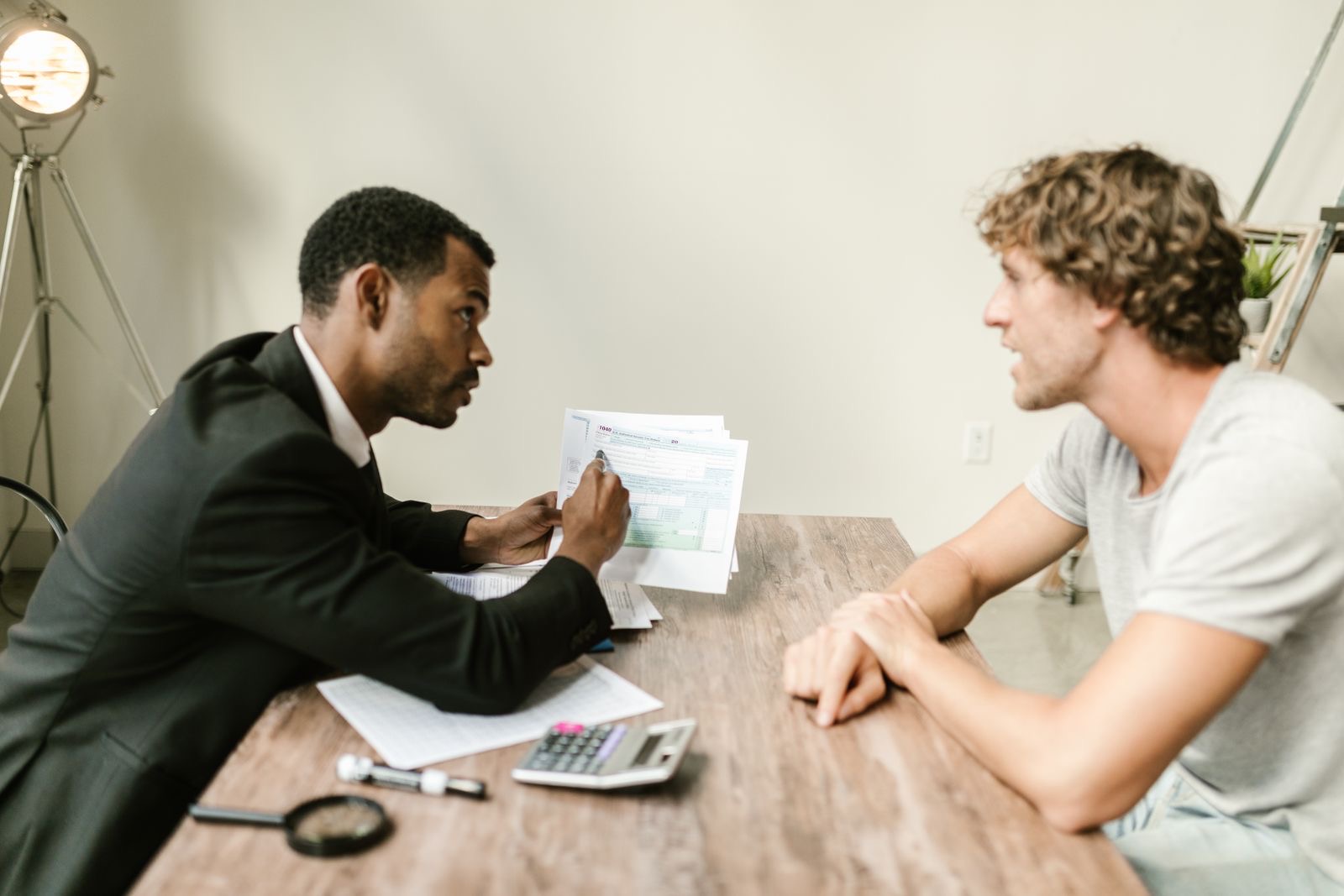 A consultant and a client reviewing residence permit documents at a desk.