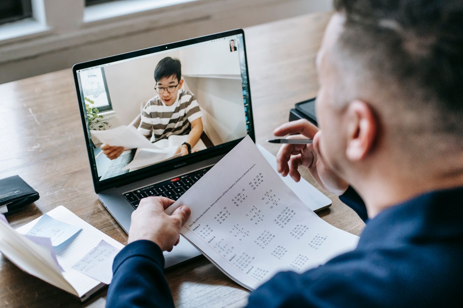 A founder abroad signing BV incorporation documents at a laptop during a video session.
