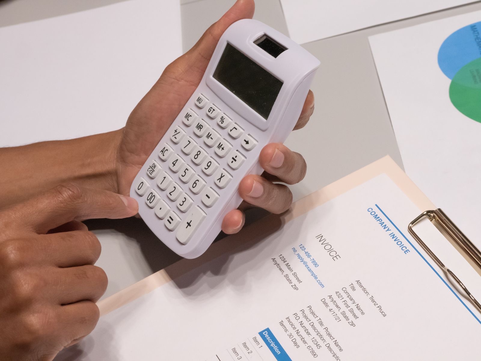 Printed invoices beside a calculator on a desk