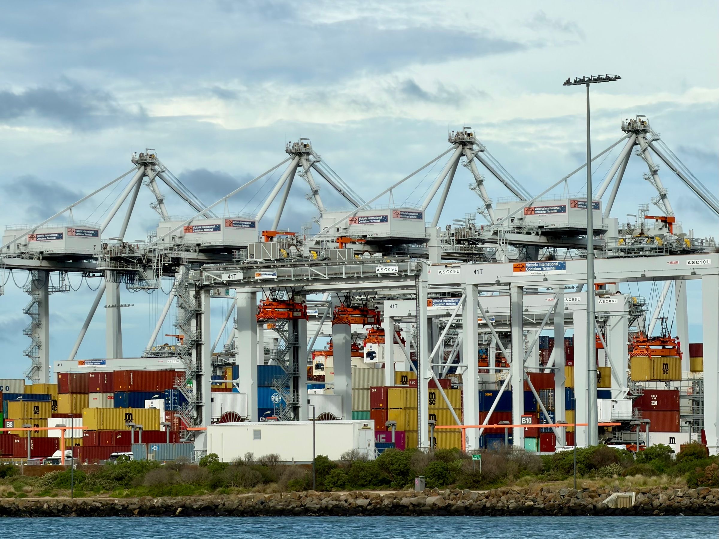 Container cranes loading and unloading ships at a port terminal, the import route the page describes.