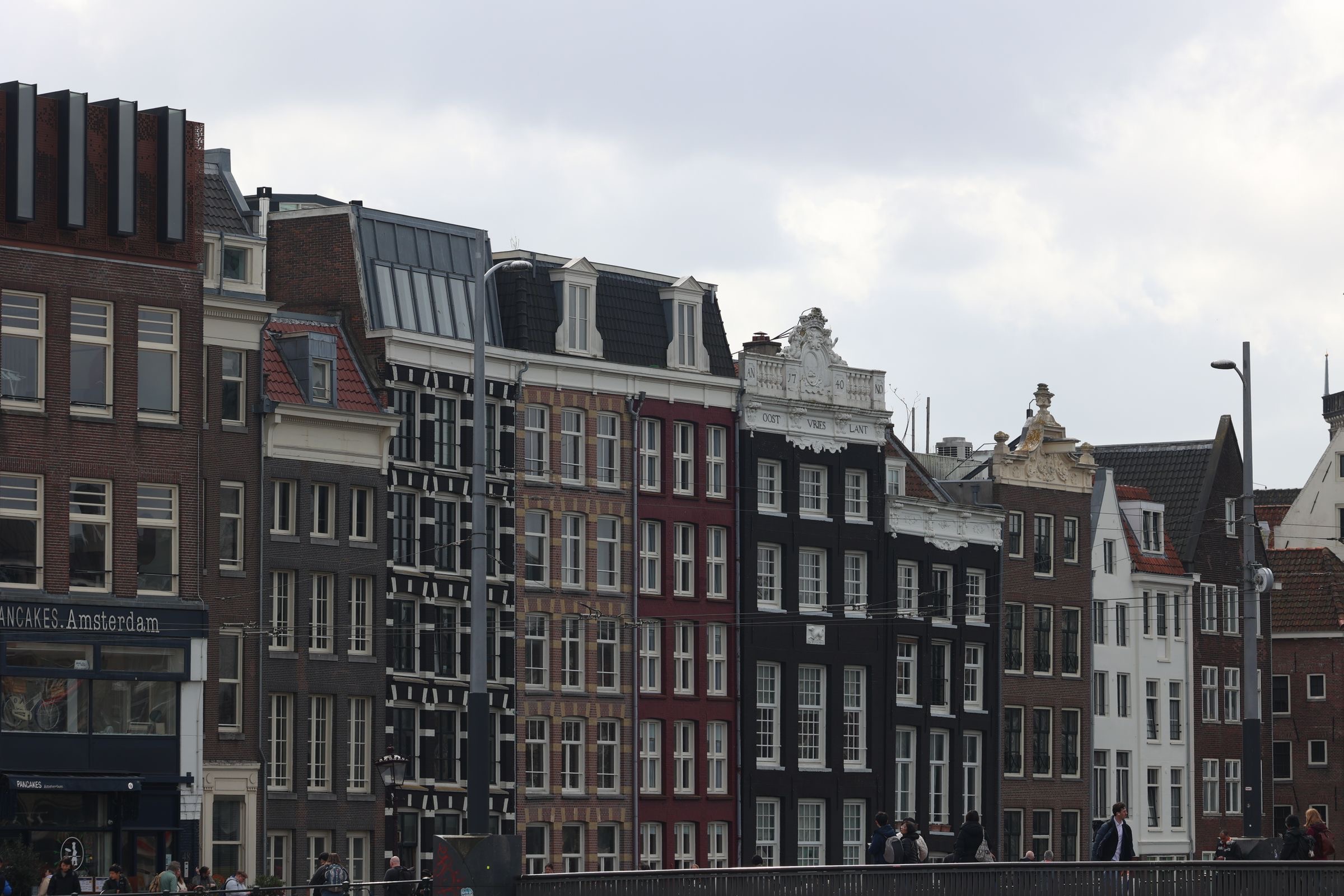 Company documents on a desk with Amsterdam canal houses in the background