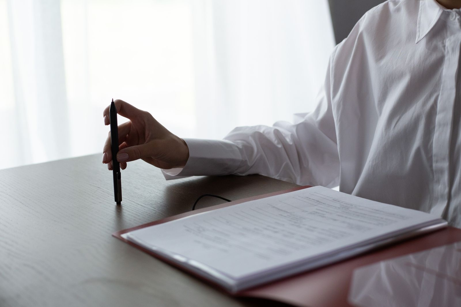 A person checking a printed company extract at a desk with a pen