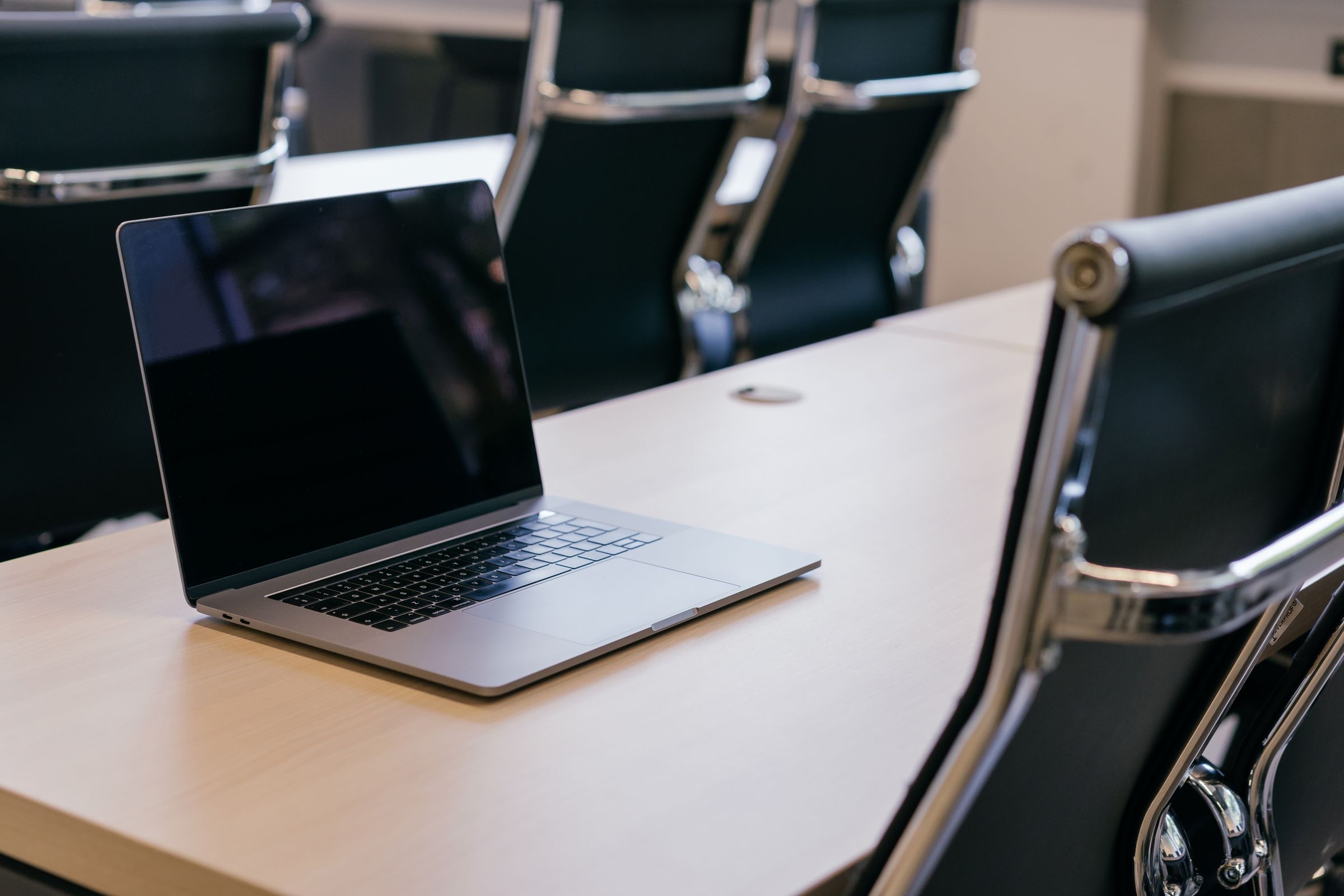 An empty chair at the head of a boardroom table