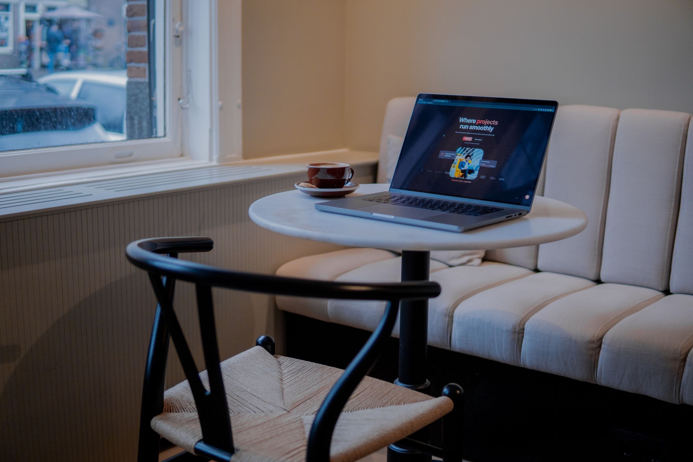 A founder planning their business at a laptop by a window in Amsterdam.