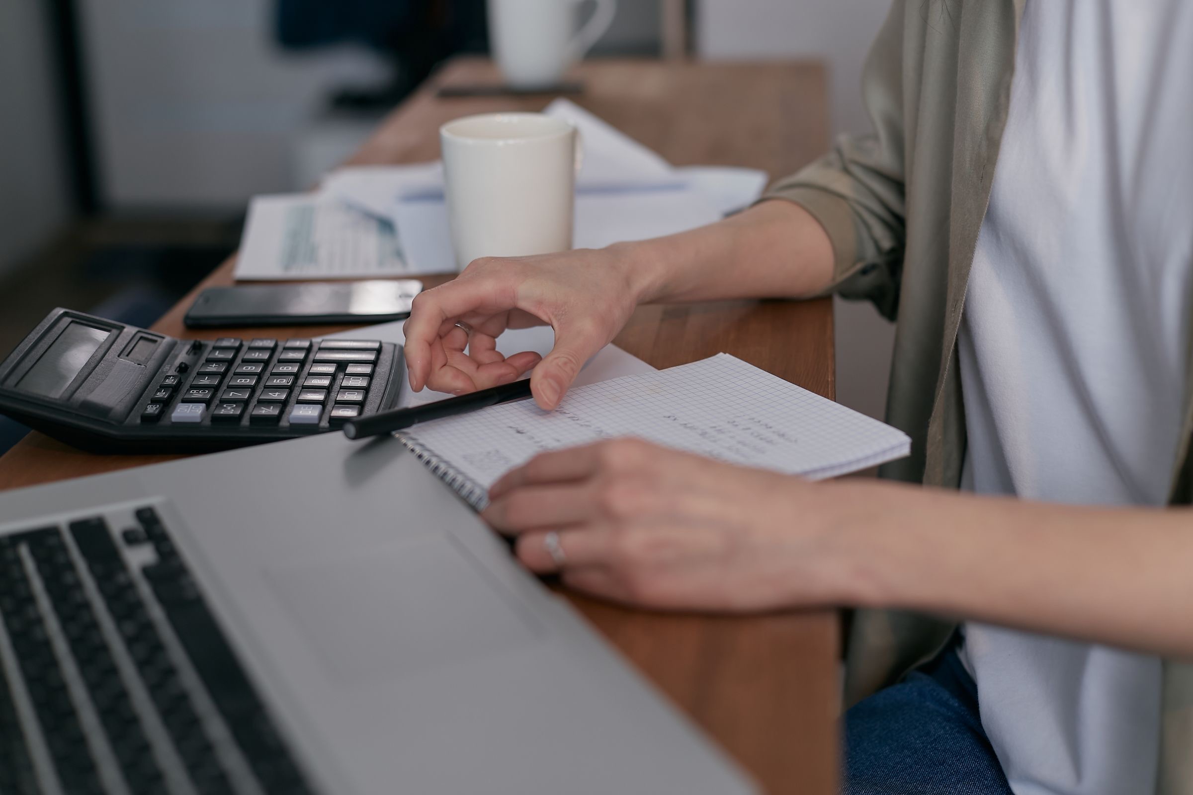 Invoices, a calculator and a laptop on a desk in an Amsterdam office